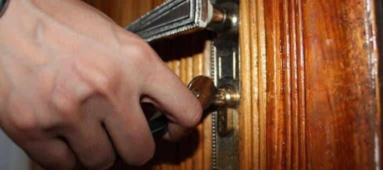 Persona cerrando la puerta de una casa con llave.