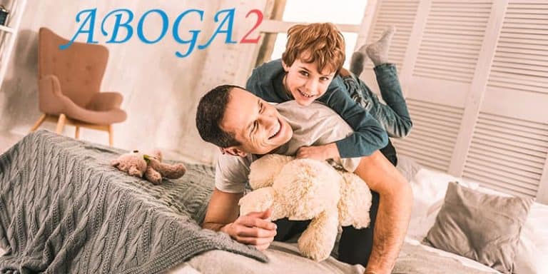 Padre e hijo jugando en la cama, representando custodia monoparental.