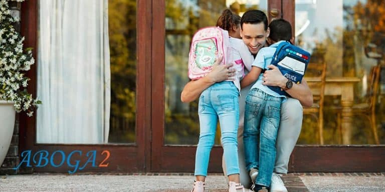 Niños con mochilas en un abrazo familiar, representando la patria potestad y su protección legal.