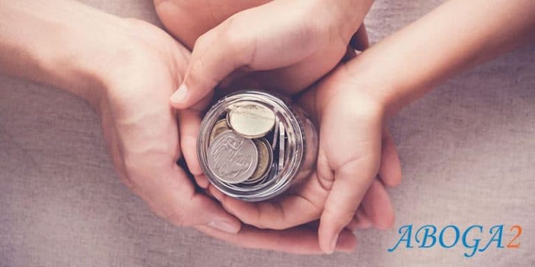 Manos sosteniendo una alcancía con monedas, símbolo de donación inoficiosa.
