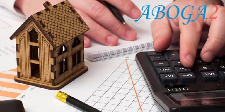 Mano calculando liquidación de gananciales con casa y gráficos financieros.