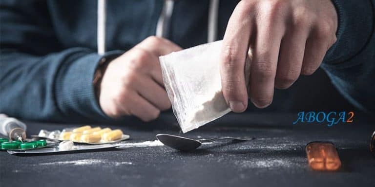 Imagen de una persona manipulando drogas y una bolsa con sustancias ilícitas.