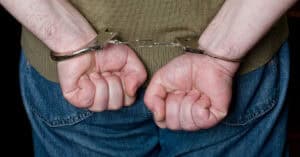 Cárcel y manos esposadas, imagen que representa la detención y el sistema judicial.