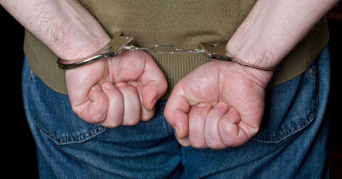 Cárcel y manos esposadas, imagen que representa la detención y el sistema judicial.