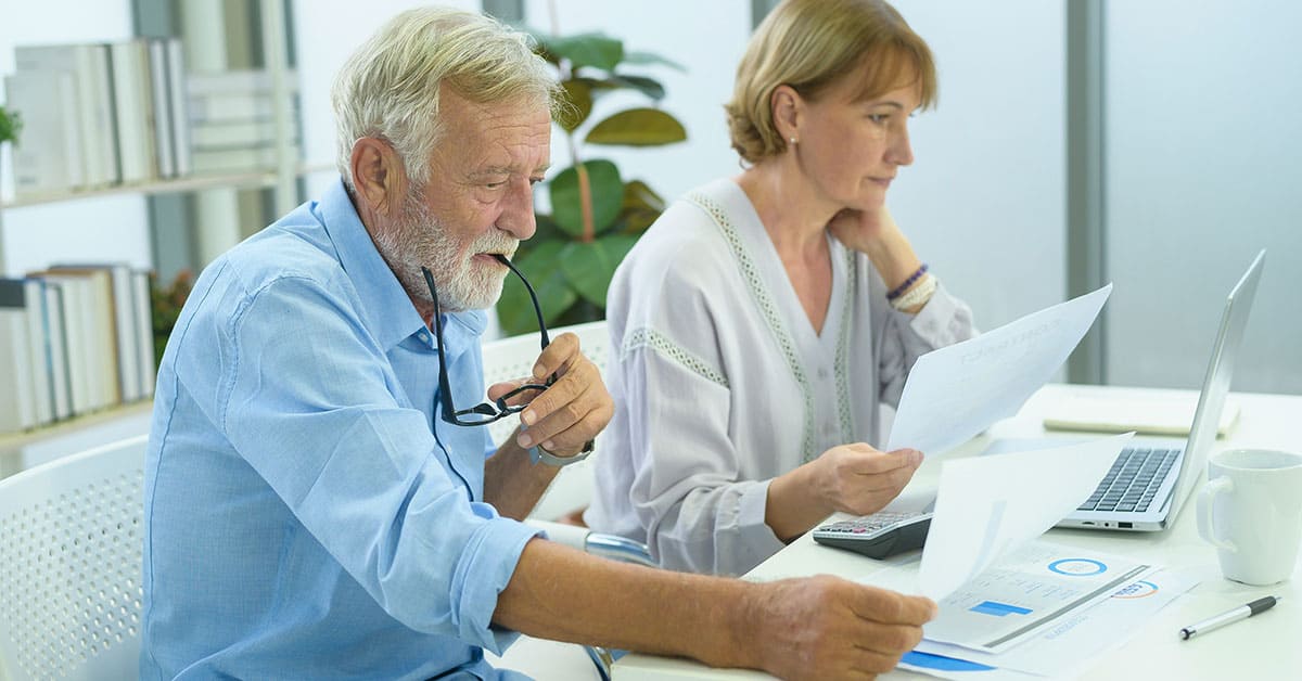 Asesor legal y abogado revisando documentos en oficina con tecnología moderna.