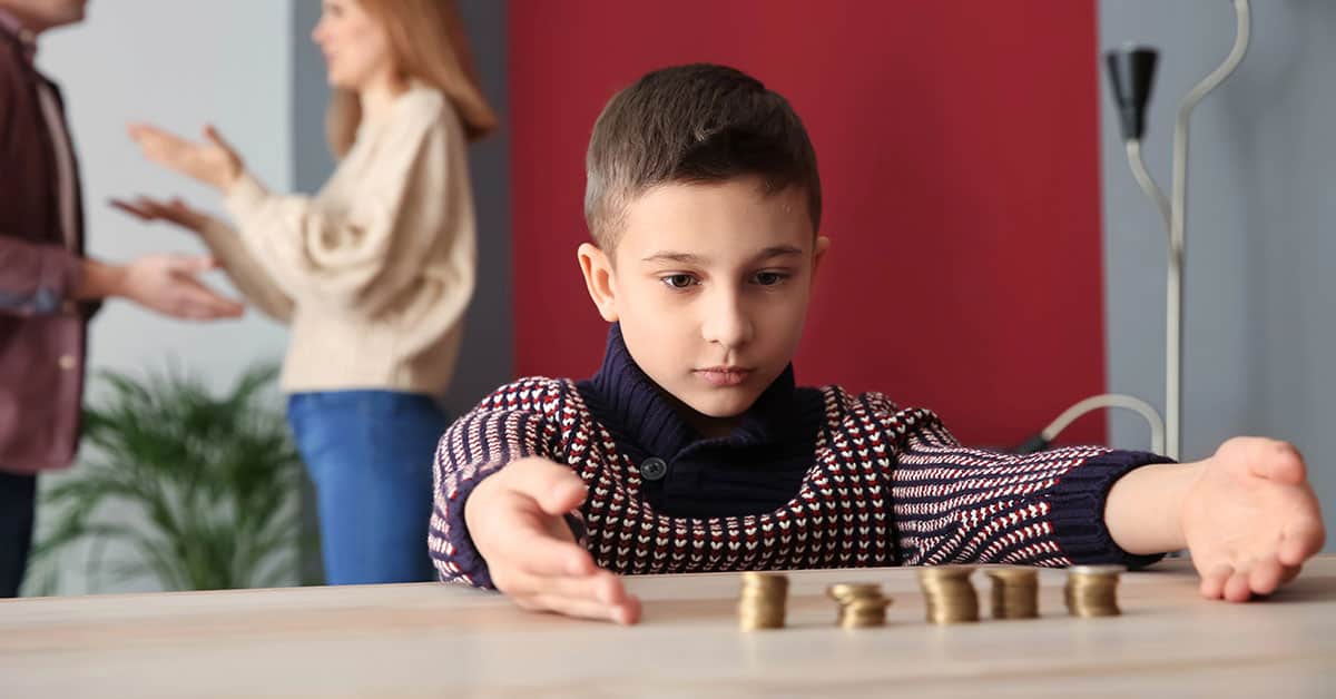 Niño contando monedas para enseñar finanzas y ahorro infantil.