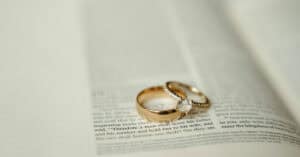 Anillos de boda dorados y con diamantes en un periódico abierto.