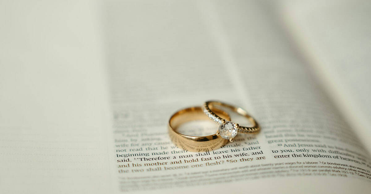 Anillos de boda dorados y con diamantes en un periódico abierto.