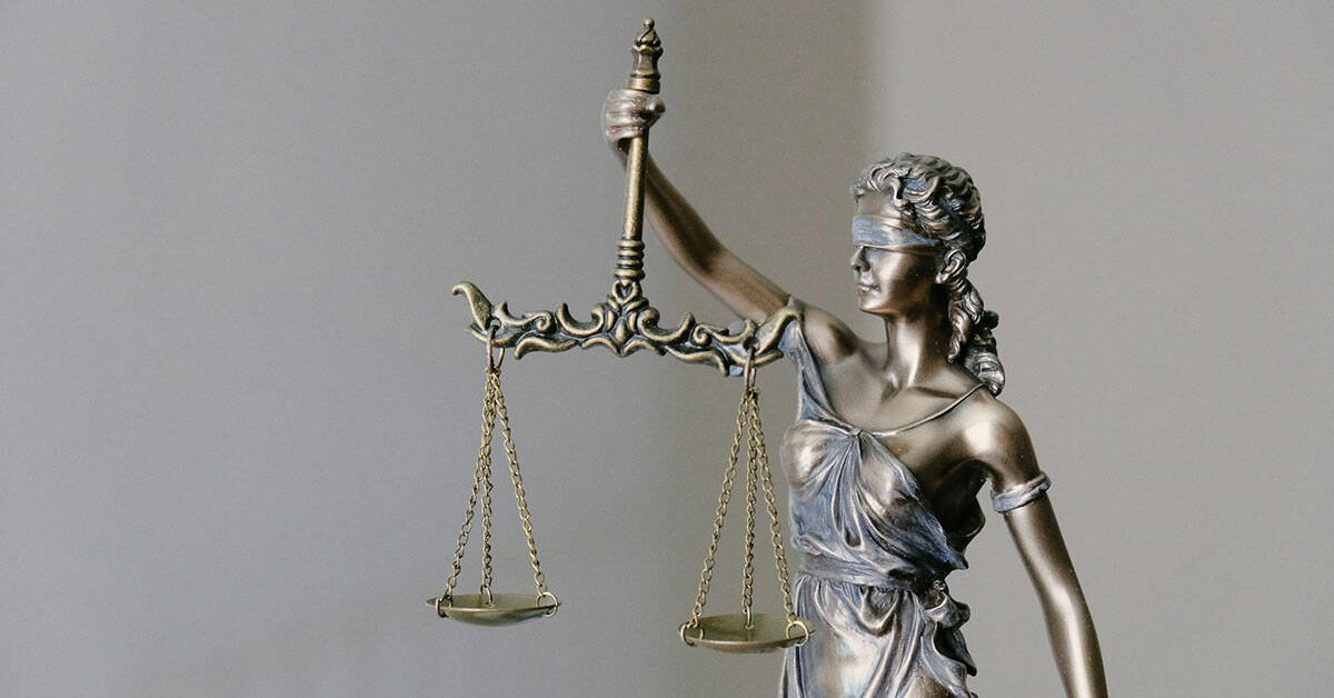 Escultura de la Justicia con balanza y espada, símbolo de equidad legal.
