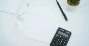 Calculadora y papeles en escritorio para gastos en custodia compartida.