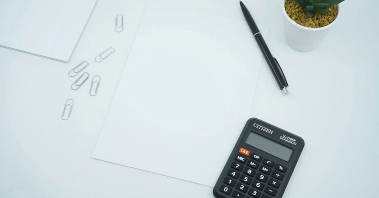 Calculadora y papeles en escritorio para gastos en custodia compartida.