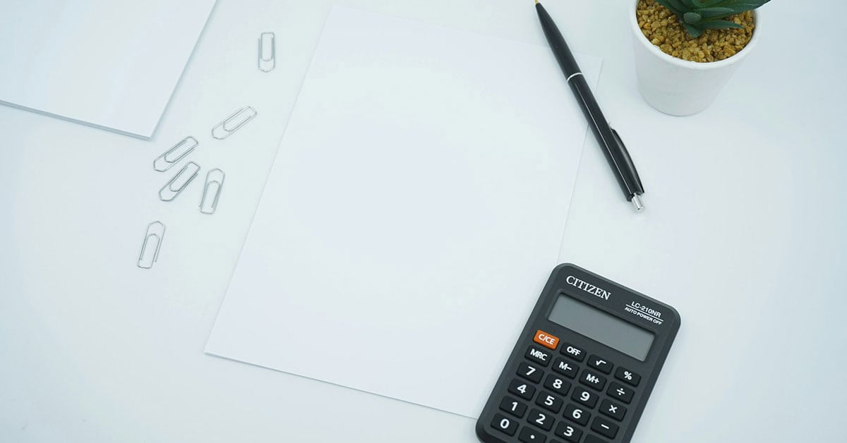 Calculadora y papeles en escritorio para gastos en custodia compartida.