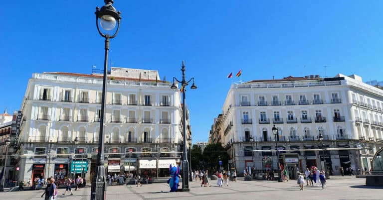 Plaza en Madrid con edificios históricos y cielo despejado.