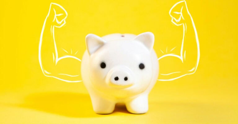 Cerdito de cerámica con músculos dibujados en fondo amarillo.