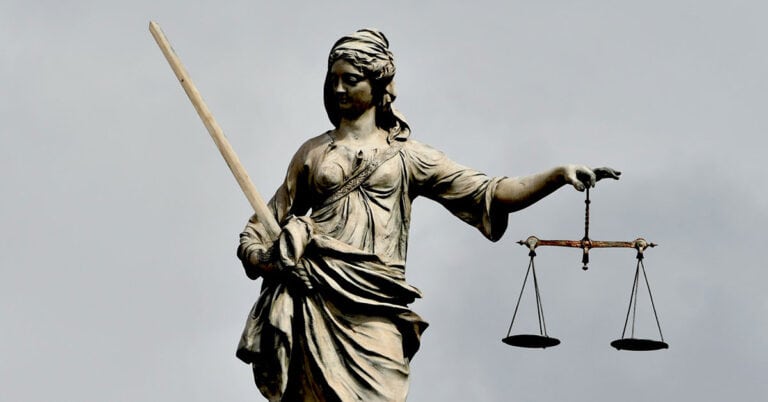 Figura de la justicia con balanza y espada, símbolo de equidad legal.